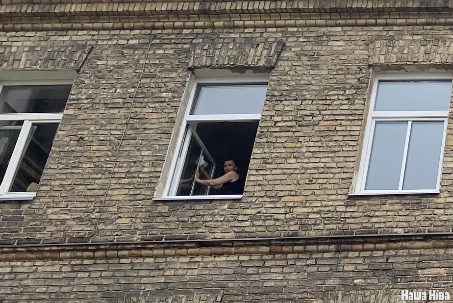 :Женщина моет окно