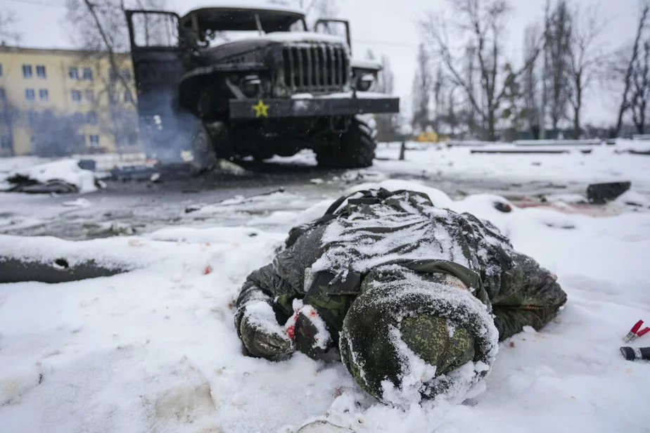 Убитый российский военнослужащий возле уничтоженной машины. Февраль 2022. Фото: AP